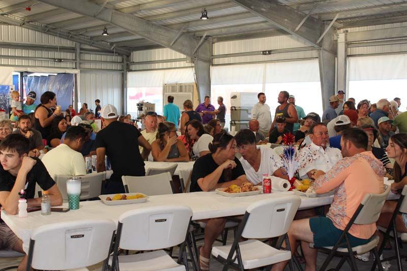 A large group of people are sitting at tables eating food