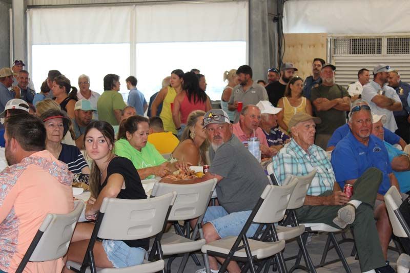 A large group of people are sitting at tables and chairs