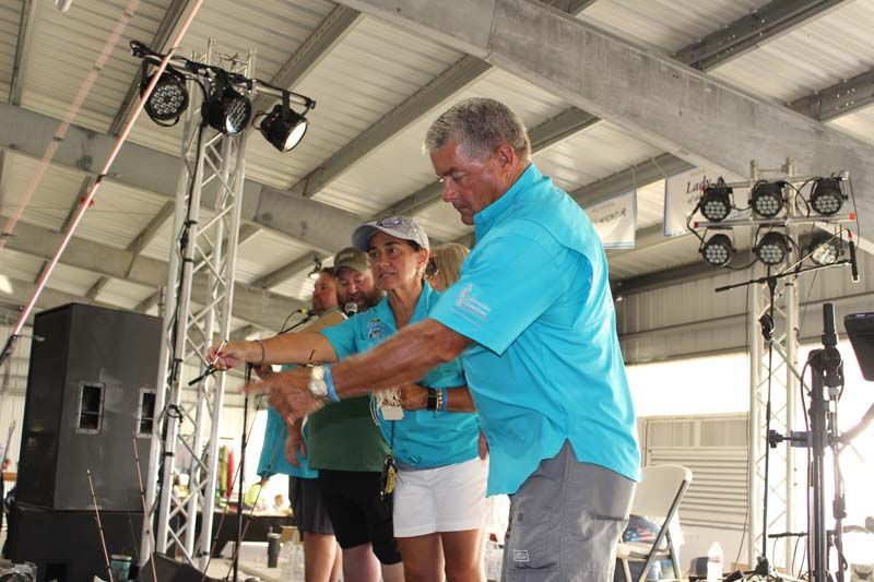 A group of people in blue shirts are standing on a stage.