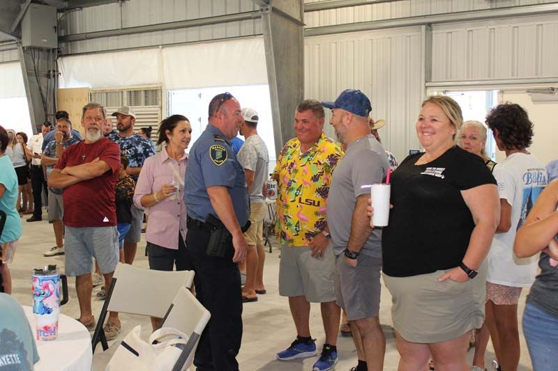 A group of people are standing in a room talking to each other.