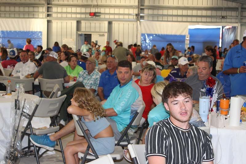 A large group of people are sitting at tables in a room.