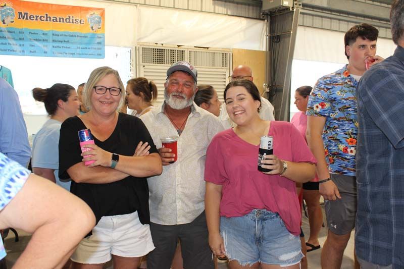 A group of people standing next to each other holding drinks.