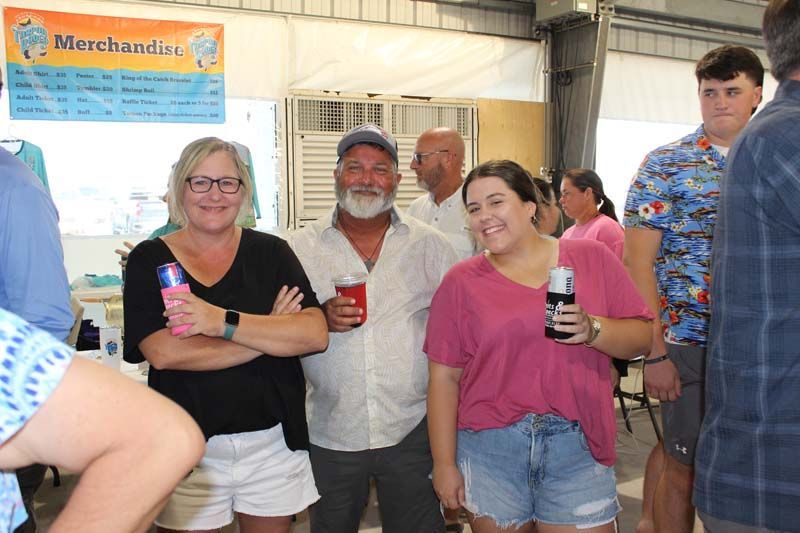 A group of people standing next to each other in front of a sign that says merchandise.