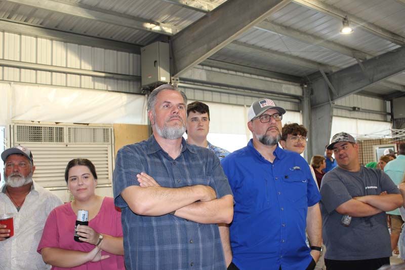 A group of people are standing in a room with their arms crossed.