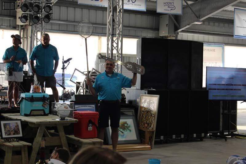 A man in a blue shirt is holding a trophy