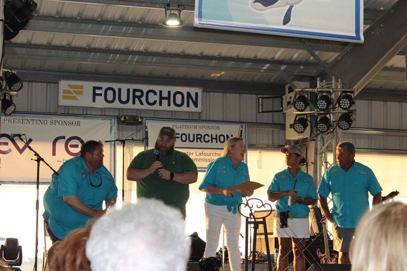 A group of men standing in front of a sign that says fourchon
