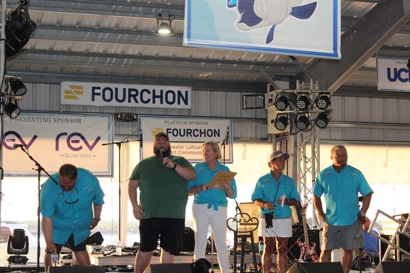 A group of people standing in front of a sign that says fourchon