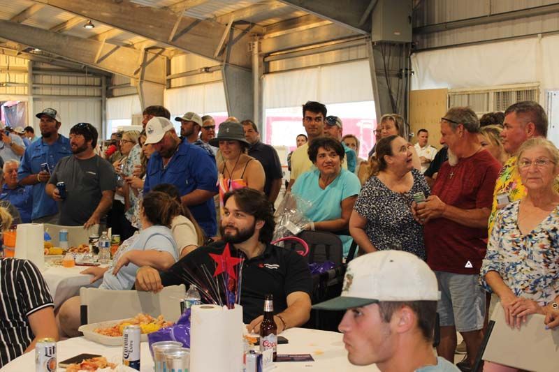 A large group of people are sitting at tables in a room.