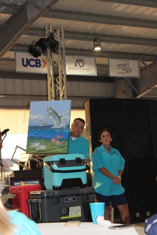 Two people standing in front of a sign that says ucb