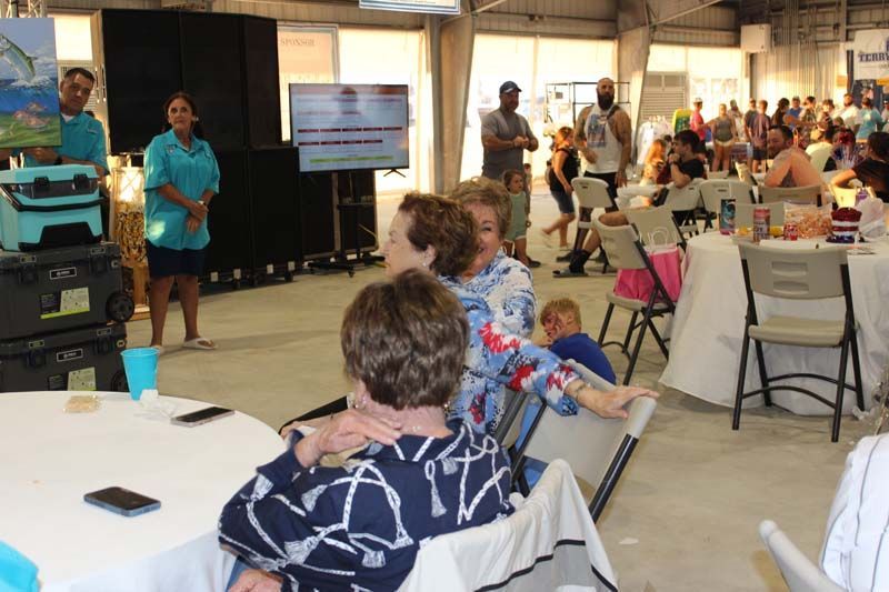 A group of people are sitting at tables in a large room.