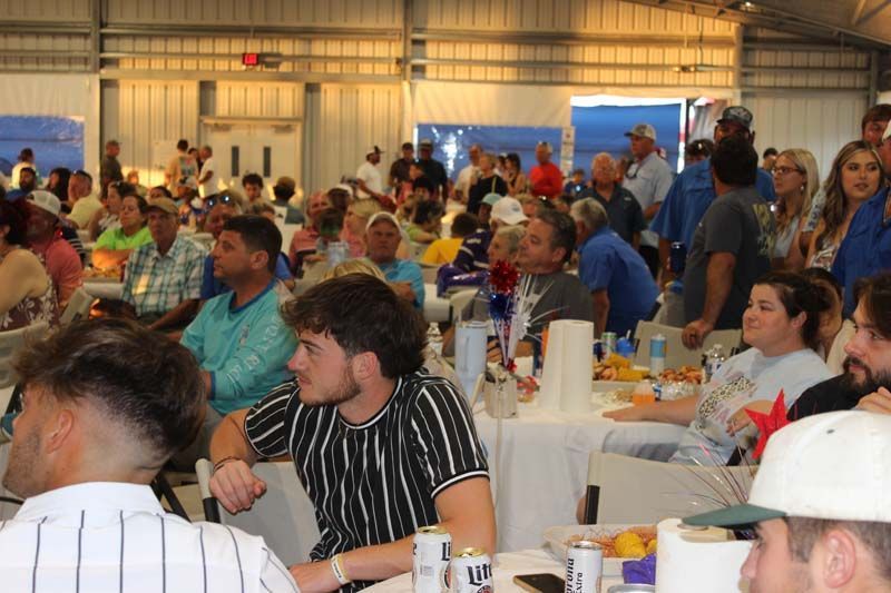 A large group of people are sitting at tables in a room.