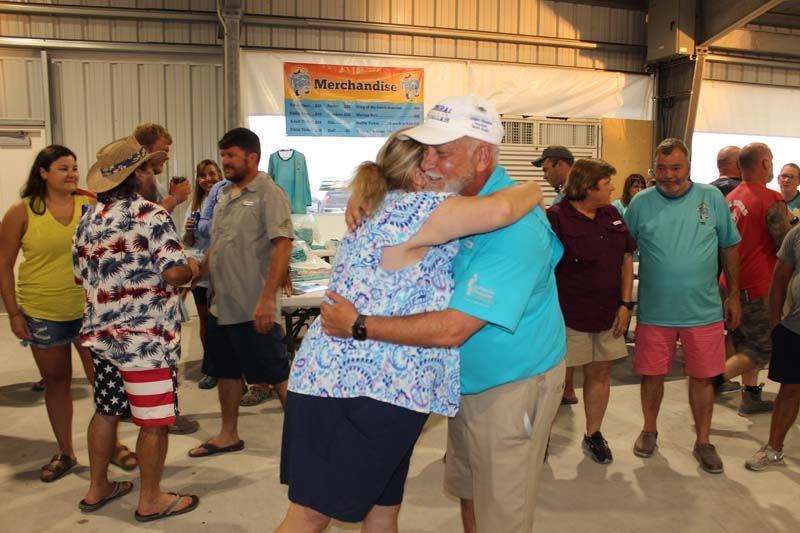 A man is hugging a woman in front of a group of people