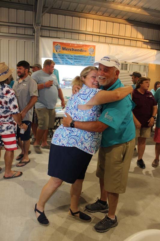 A man is hugging a woman in a crowd of people.