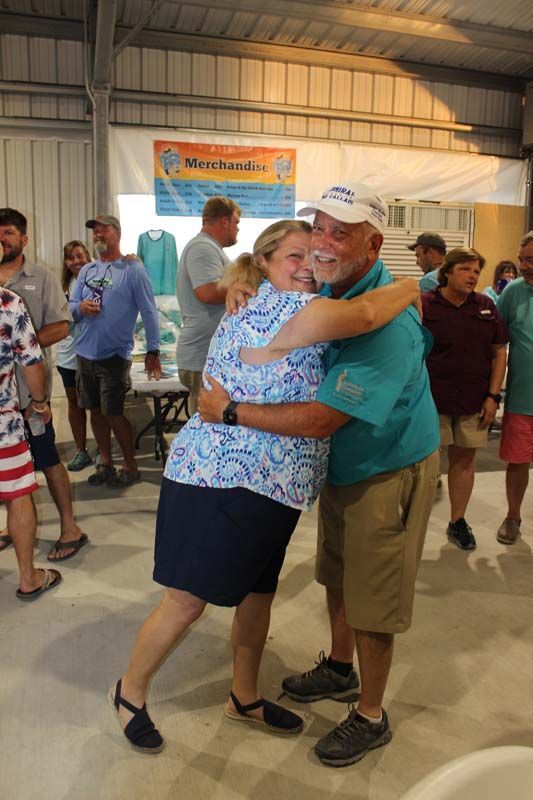 A man is hugging a woman in front of a crowd of people.