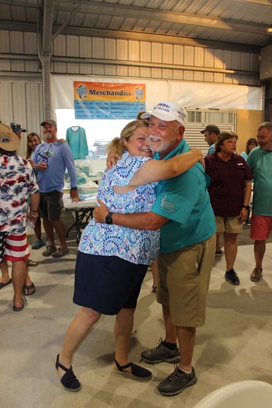 A man and a woman are hugging each other in a room.