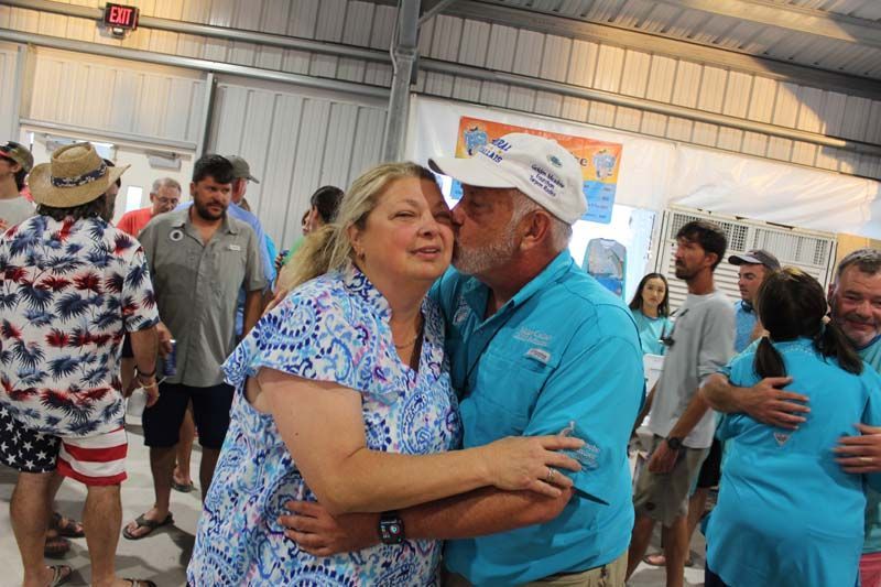 A man is kissing a woman on the cheek at a party.