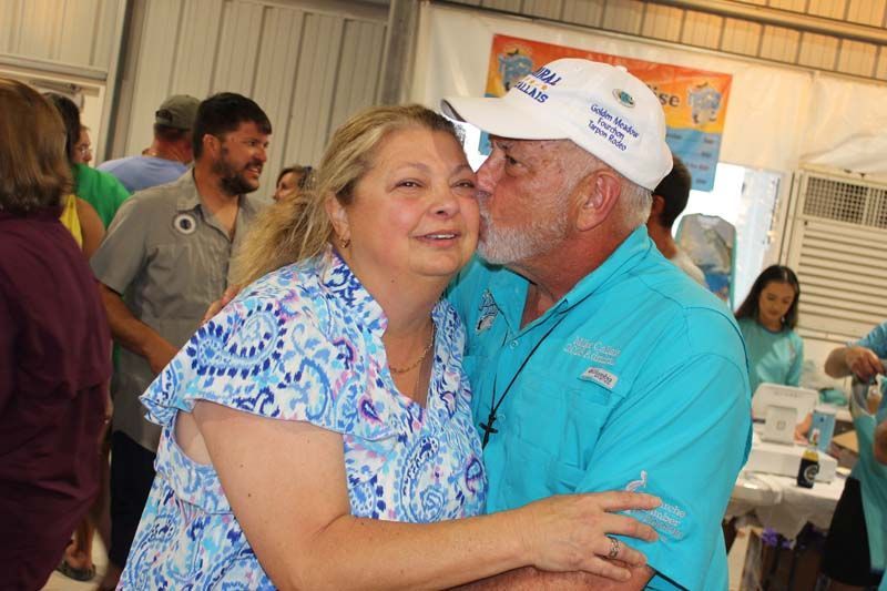 A man is kissing a woman on the cheek at a party.