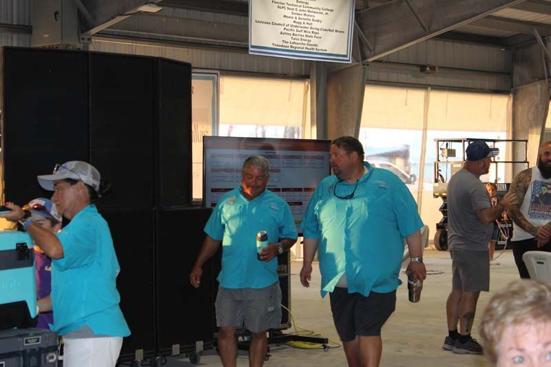 A group of people in blue shirts are standing in a room.
