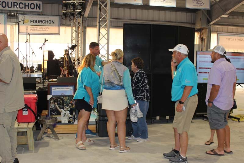 A group of people standing in front of a fourchon sign