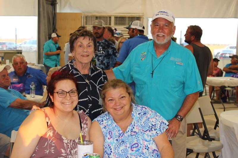 A group of people are posing for a picture while sitting at a table.