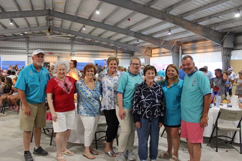 A group of people are posing for a picture in a large room.