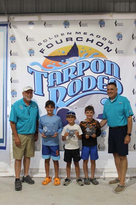 A group of people standing in front of a banner that says tarpon dodge