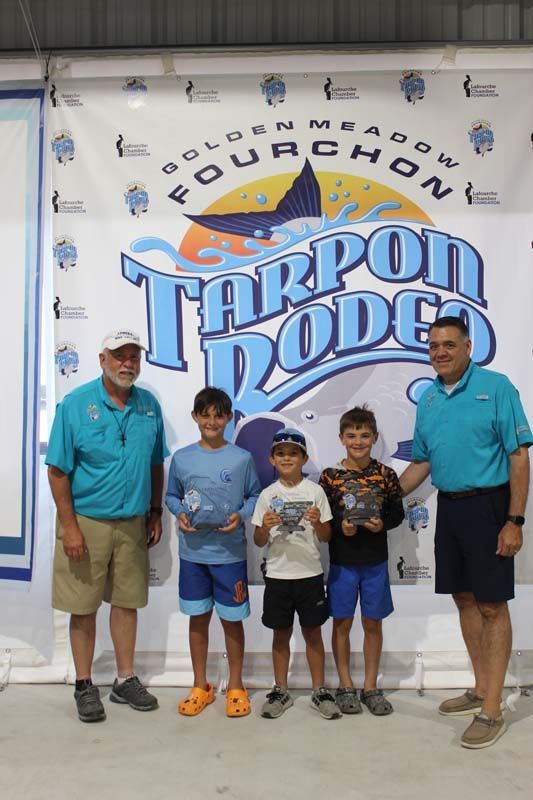 A group of people standing in front of a tarpon dodge sign