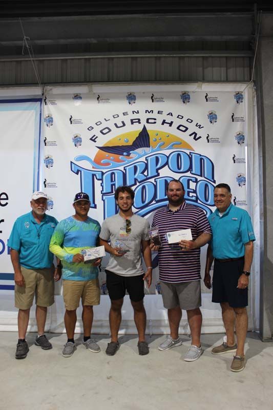 A group of men are posing for a picture in front of a banner.