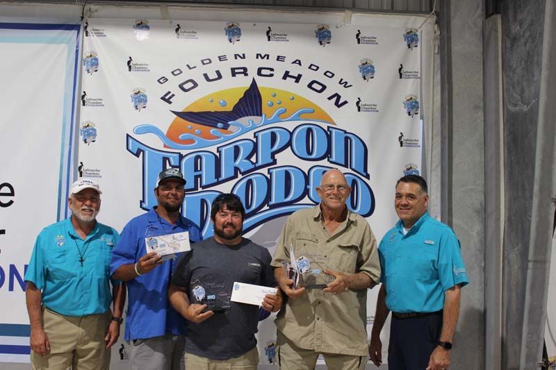 A group of men are standing in front of a banner that says fourchon