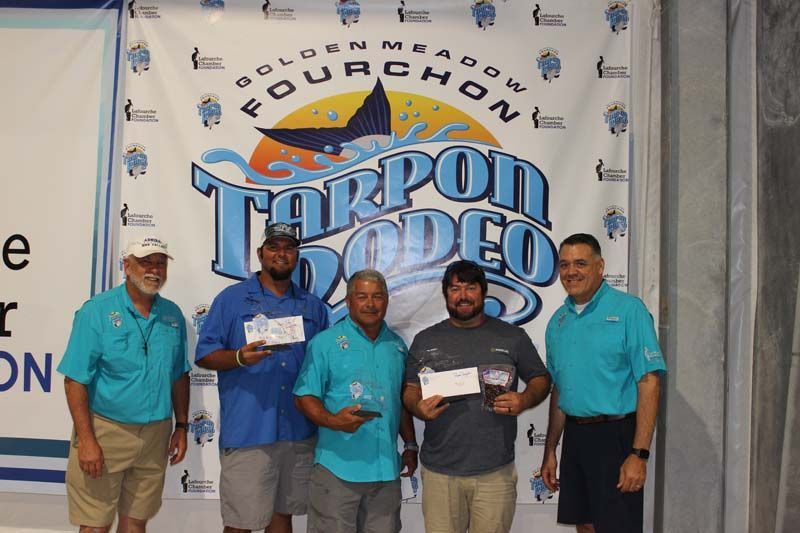 A group of men standing in front of a banner that says fourchon