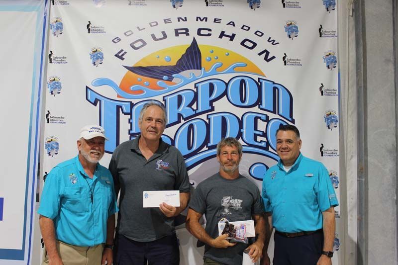 Four men standing in front of a banner that says fourchon