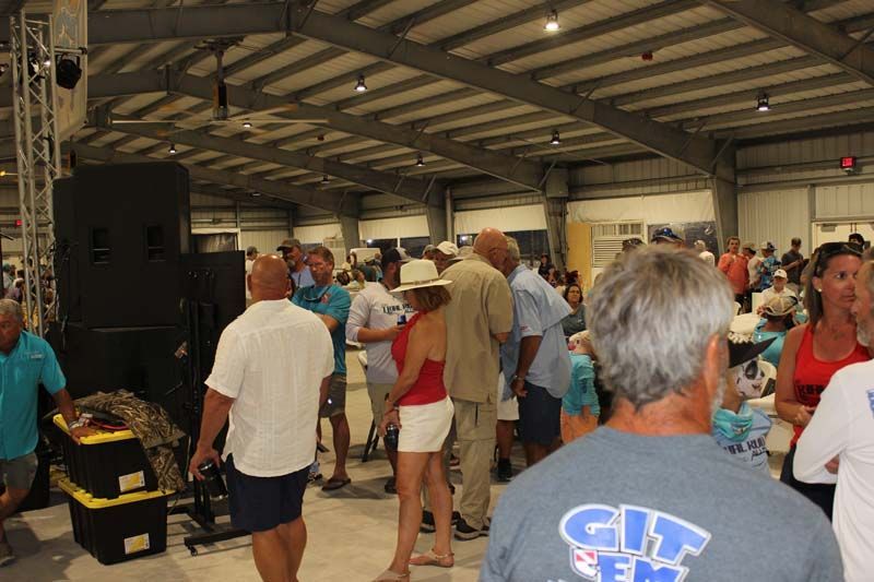 A group of people are standing in a room and one man is wearing a shirt that says city
