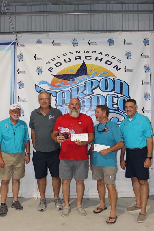 A group of men are posing for a picture in front of a banner.
