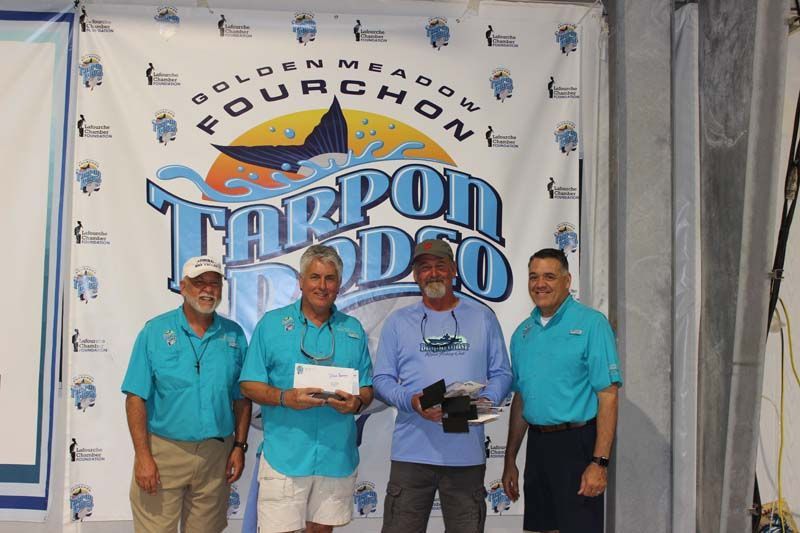 A group of men standing in front of a banner that says fourchon