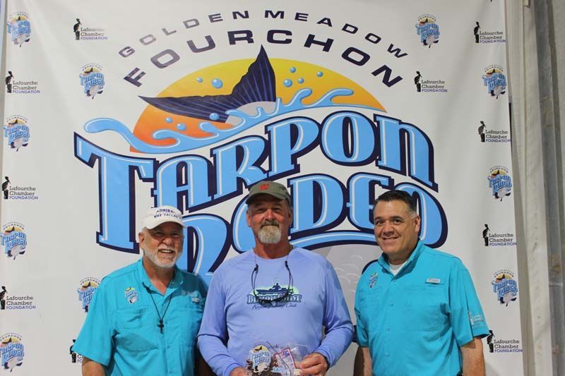 Three men standing in front of a banner that says tarpon dodge