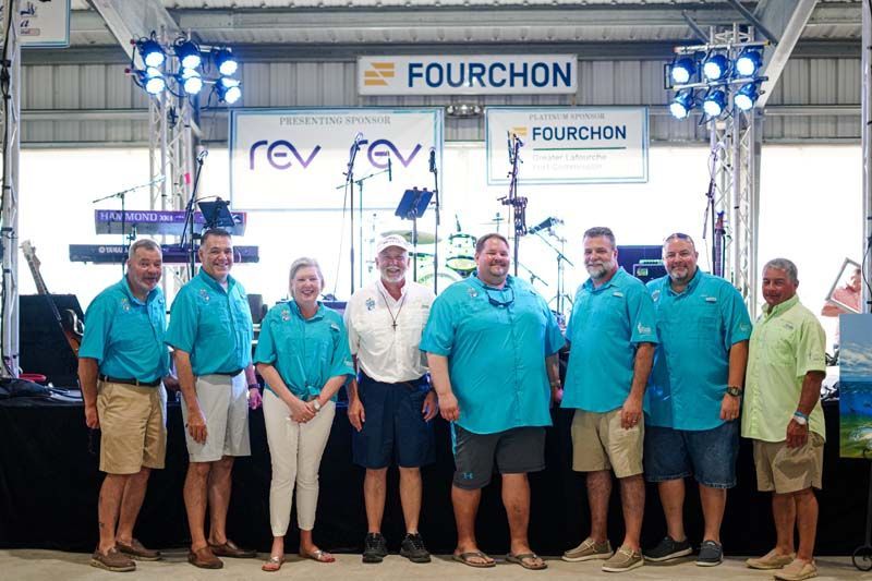 A group of people are posing for a picture in front of a stage.