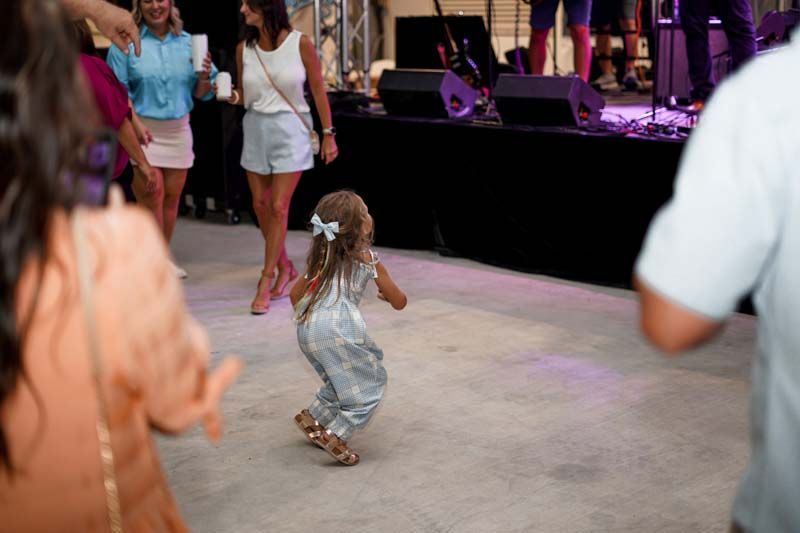A little girl is dancing on a dance floor at a party.