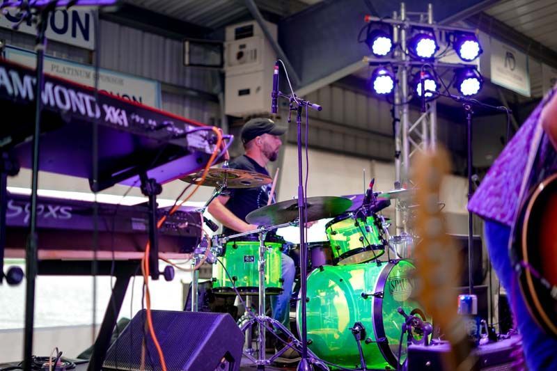 A man playing drums in front of a keyboard that says ammond