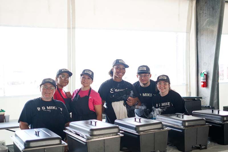 A group of people are posing for a picture in a kitchen.