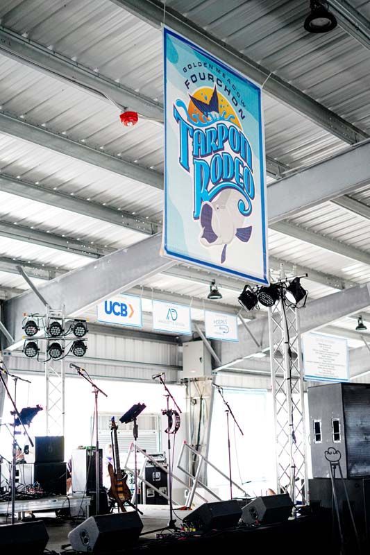 A large banner is hanging from the ceiling above a stage.