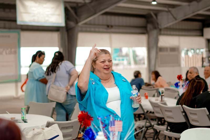 A woman is standing in a room holding a bottle of water.