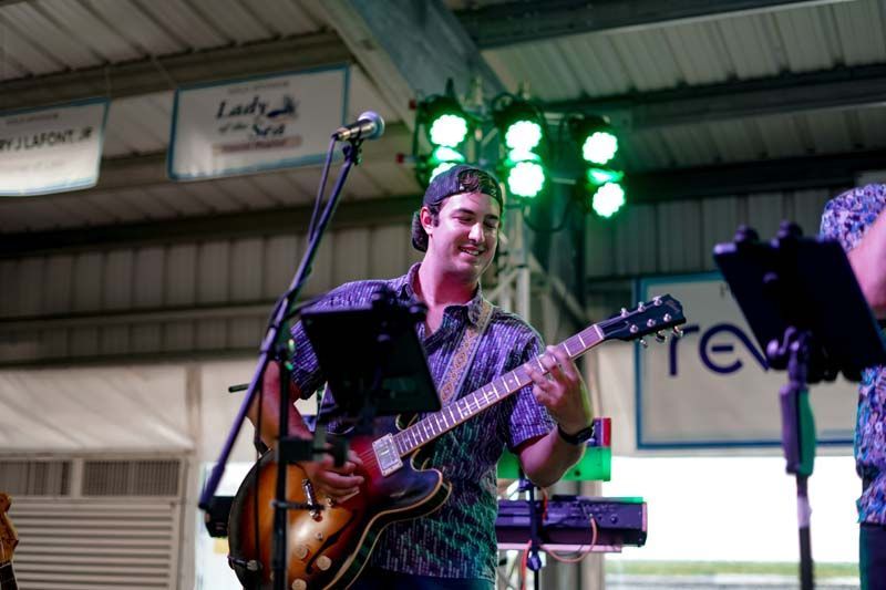 A man is playing a guitar and singing into a microphone.