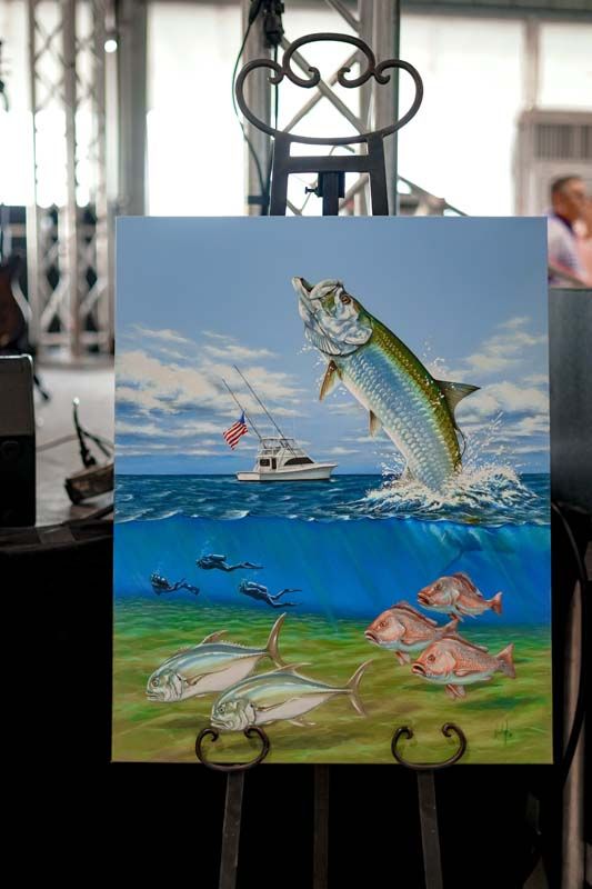 A painting of a fish jumping out of the water on an easel.