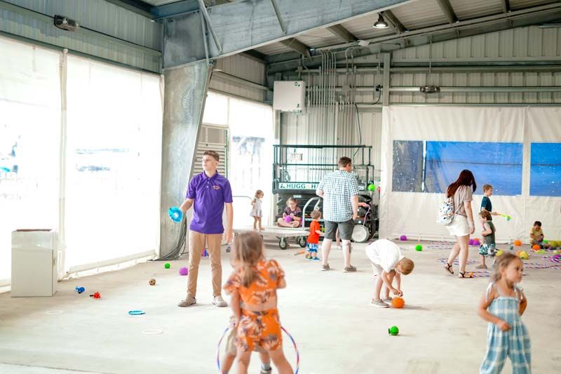 A group of children are playing in a large room filled with toys.