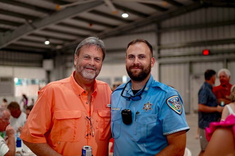 Two men are posing for a picture together in a building.