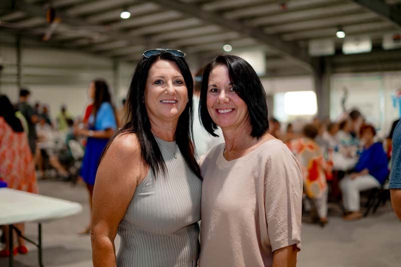 Two women are posing for a picture together in a room.