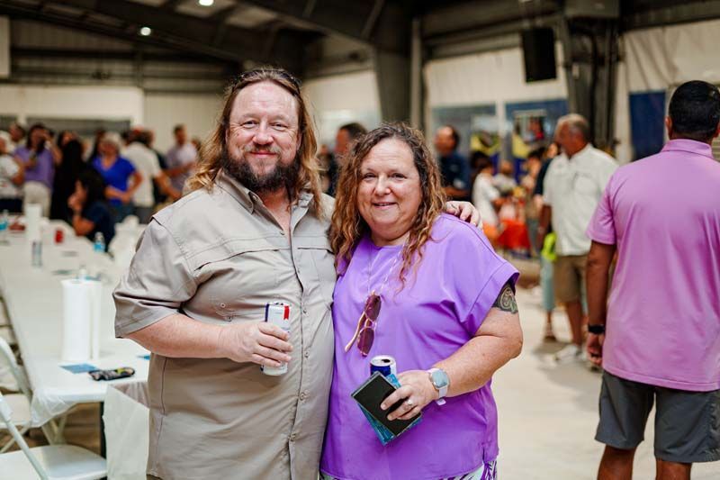 A man and a woman are posing for a picture at a party.