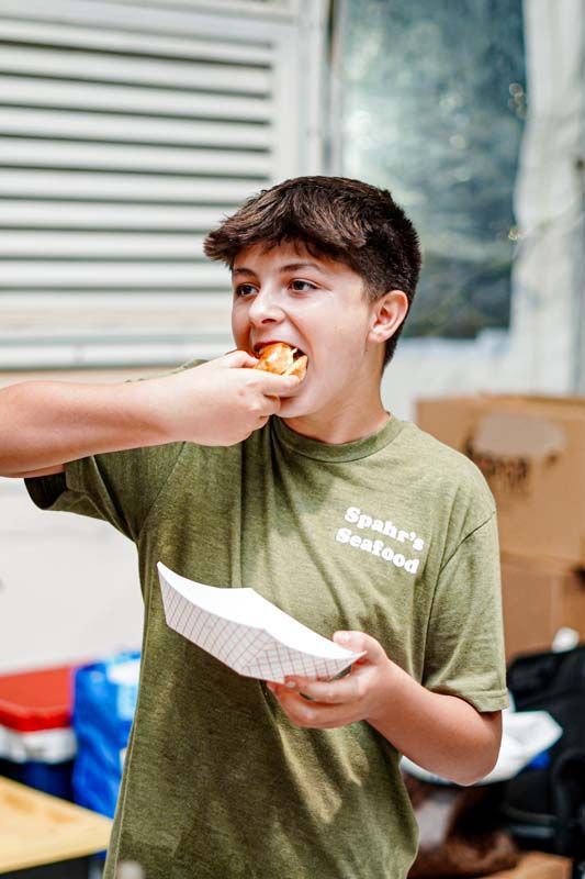 young boy in green shirt eating
