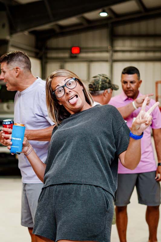 A woman is making a funny face while standing in front of a group of people.
