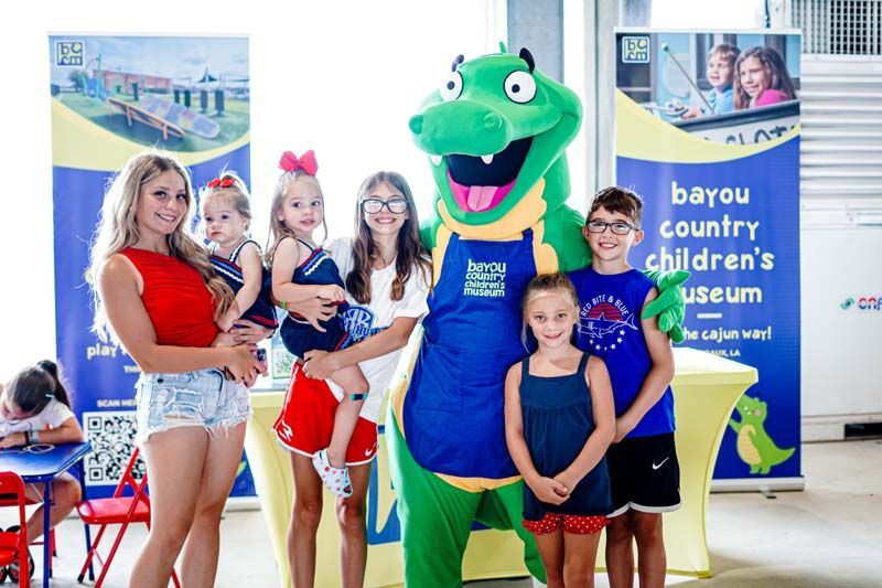 A group of children are posing for a picture with a mascot.